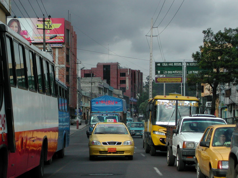 cars and busses travelling on the same street