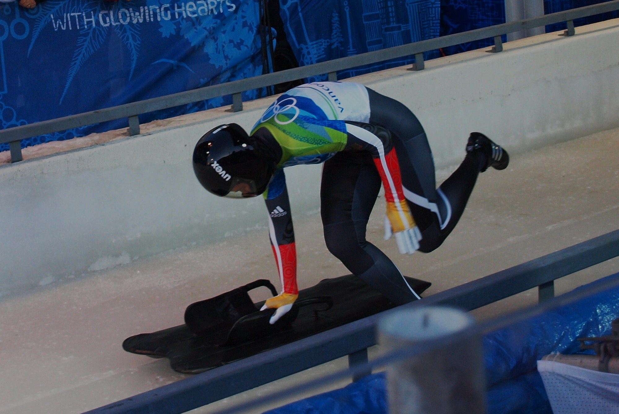 an olympic athlete leans forward on his skis