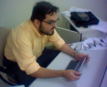 a man wearing glasses and using a laptop computer