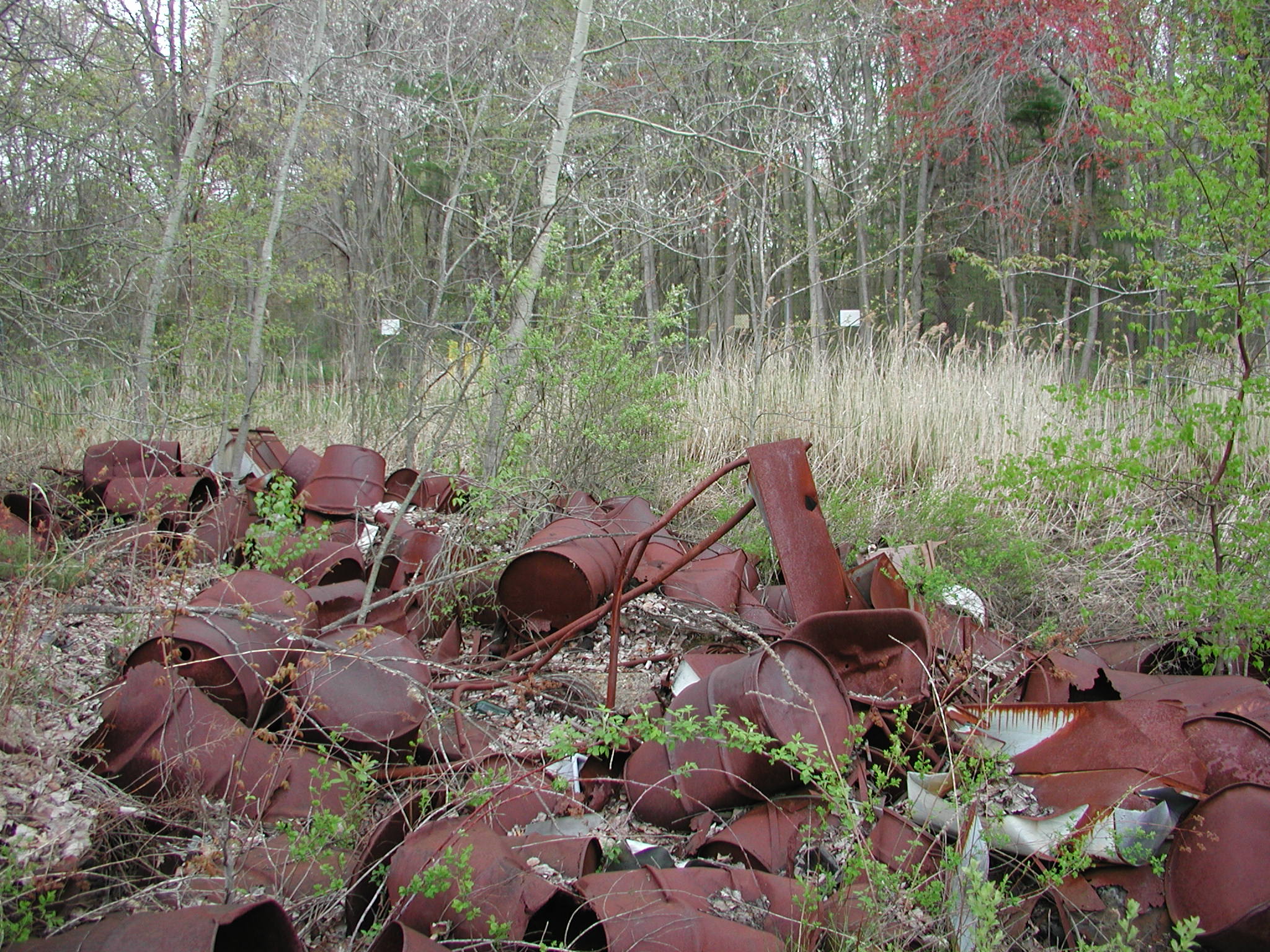 there is a pile of old rusted out pipes in a field