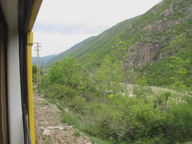 the view out of a train window on a mountain side