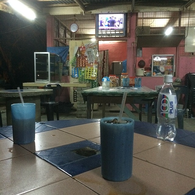 a room with table, two empty drinks and a television