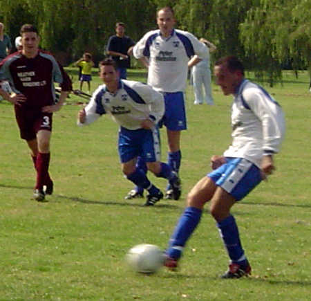 a group of men playing soccer on a green field