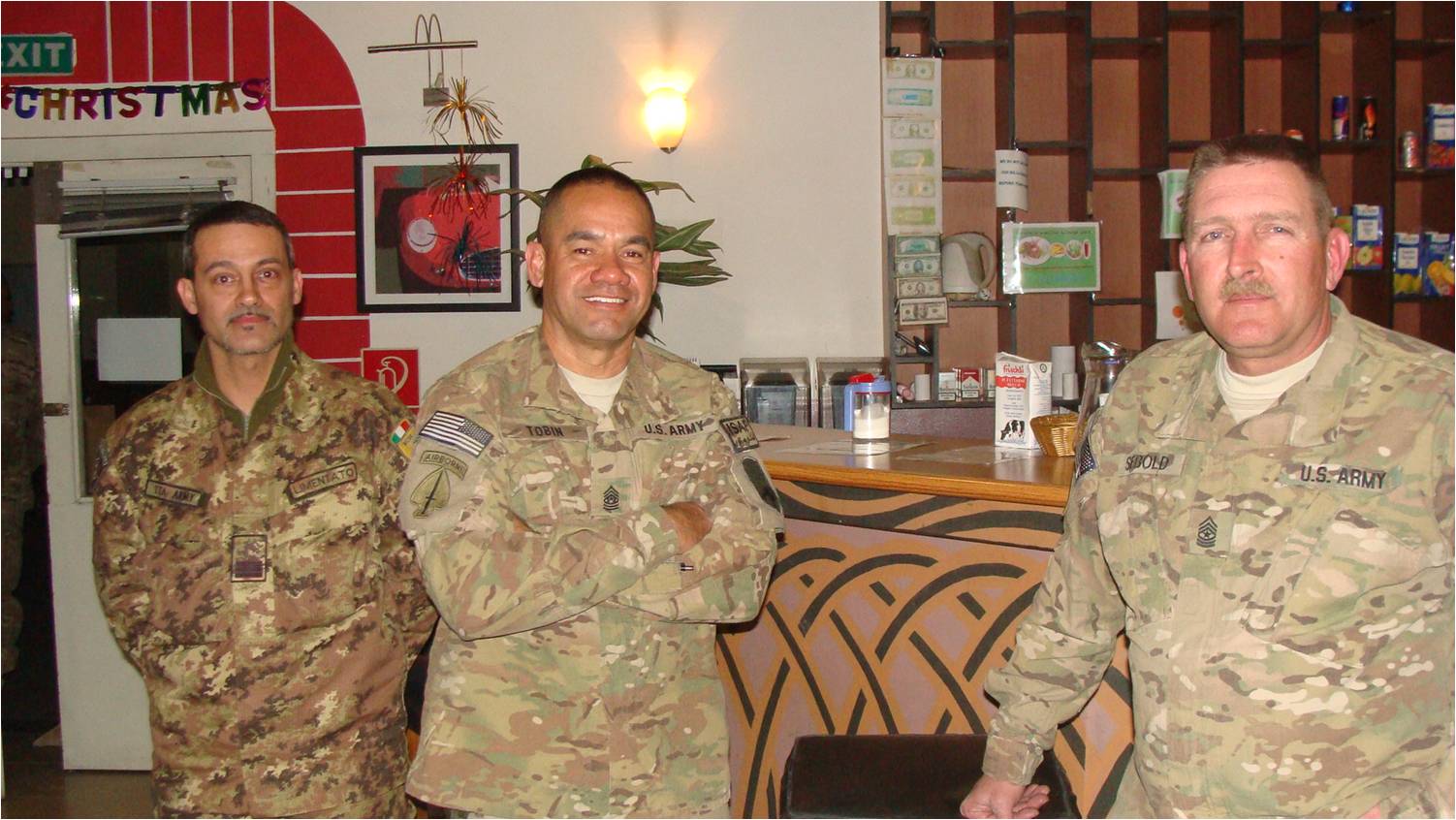 men in army fatigues standing near each other in a restaurant