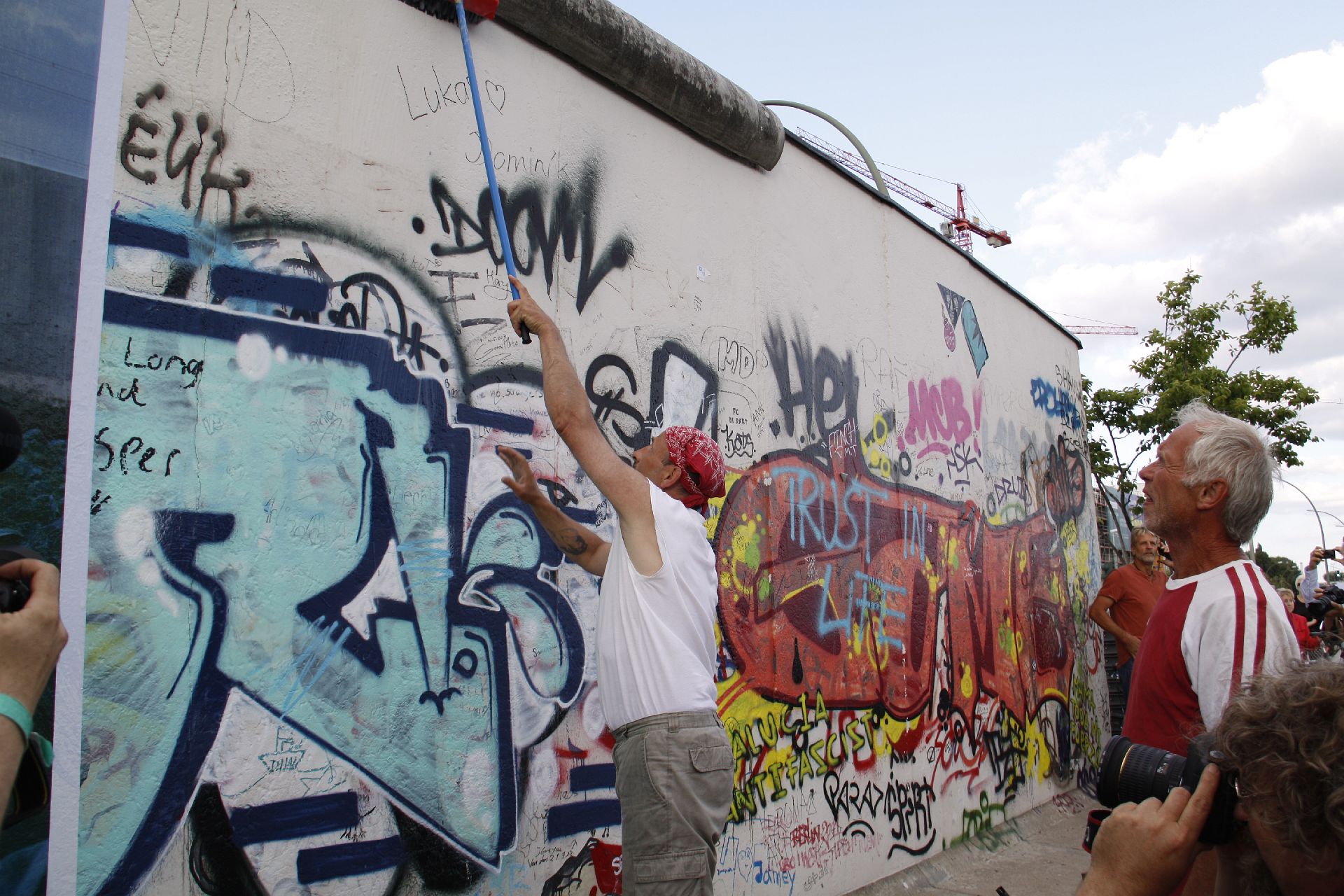 a man painting on a wall with graffiti