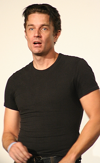 a man wearing a black tshirt holding his hands in his pockets