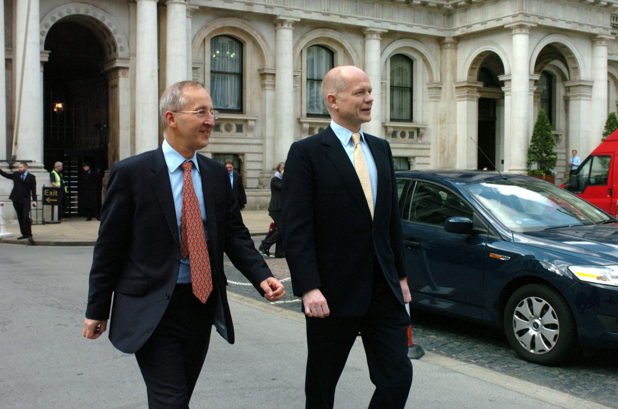 two older men walking in front of a building