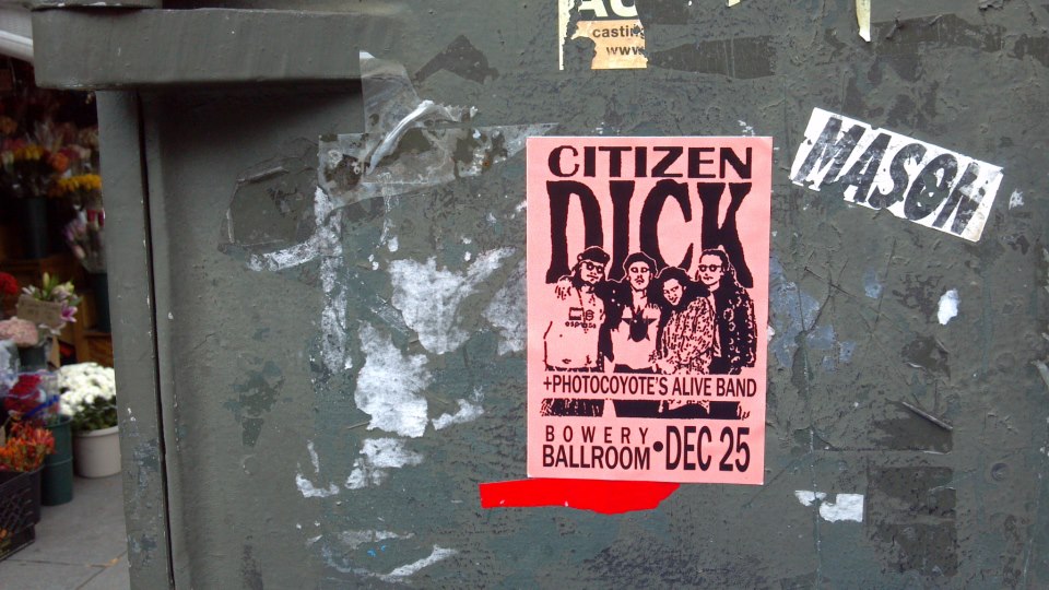 a poster taped to a wall in a city