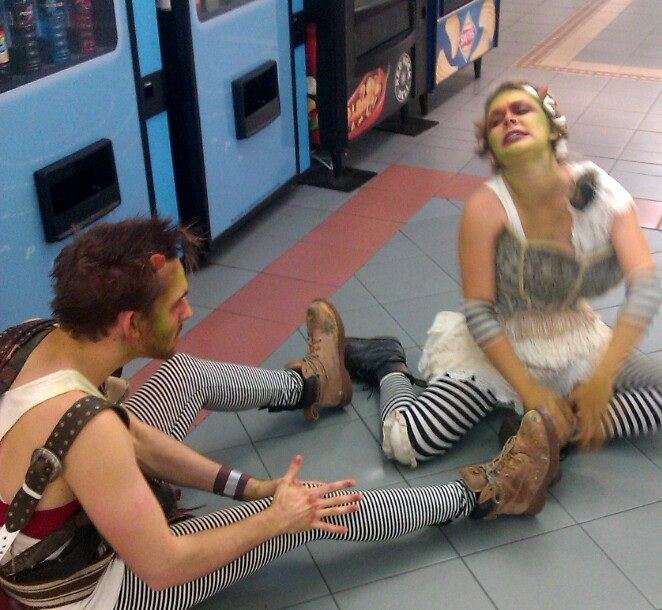 a man and woman wearing costumes sit in the middle of a floor