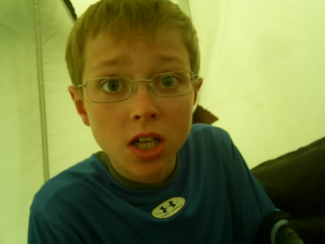 boy with glasses showing off tongue at camera