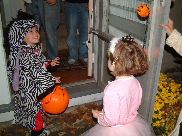 two young children dressed up for halloween outside a house