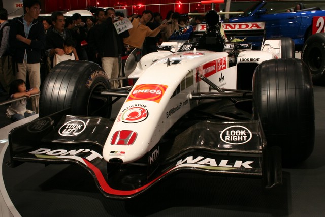 a racing car on display in front of a crowd of people