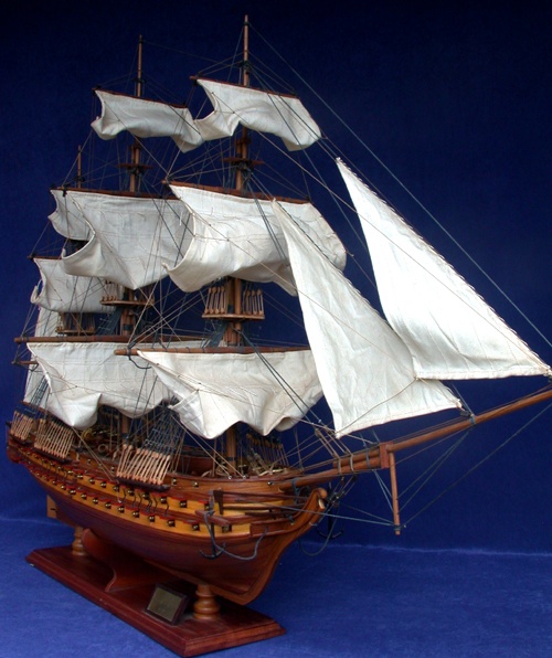 a wooden model ship is in white paint