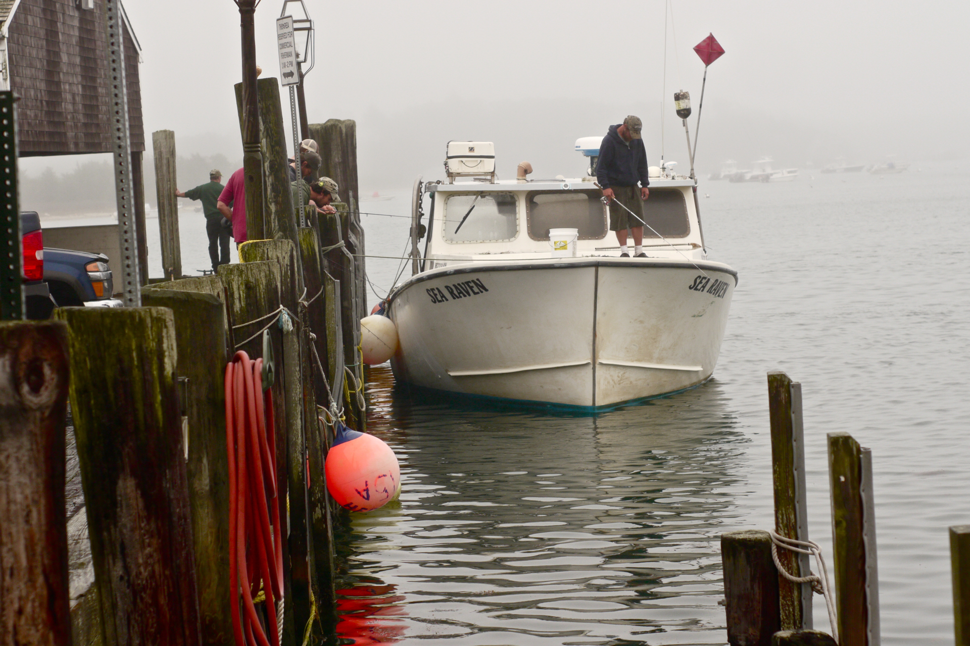 a small white boat moored on a foggy day