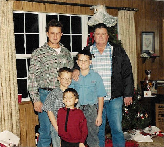 an old po of a man with two boys in front of a christmas tree