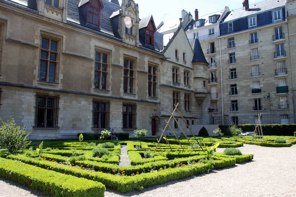 a courtyard filled with large buildings and trimmed lawn