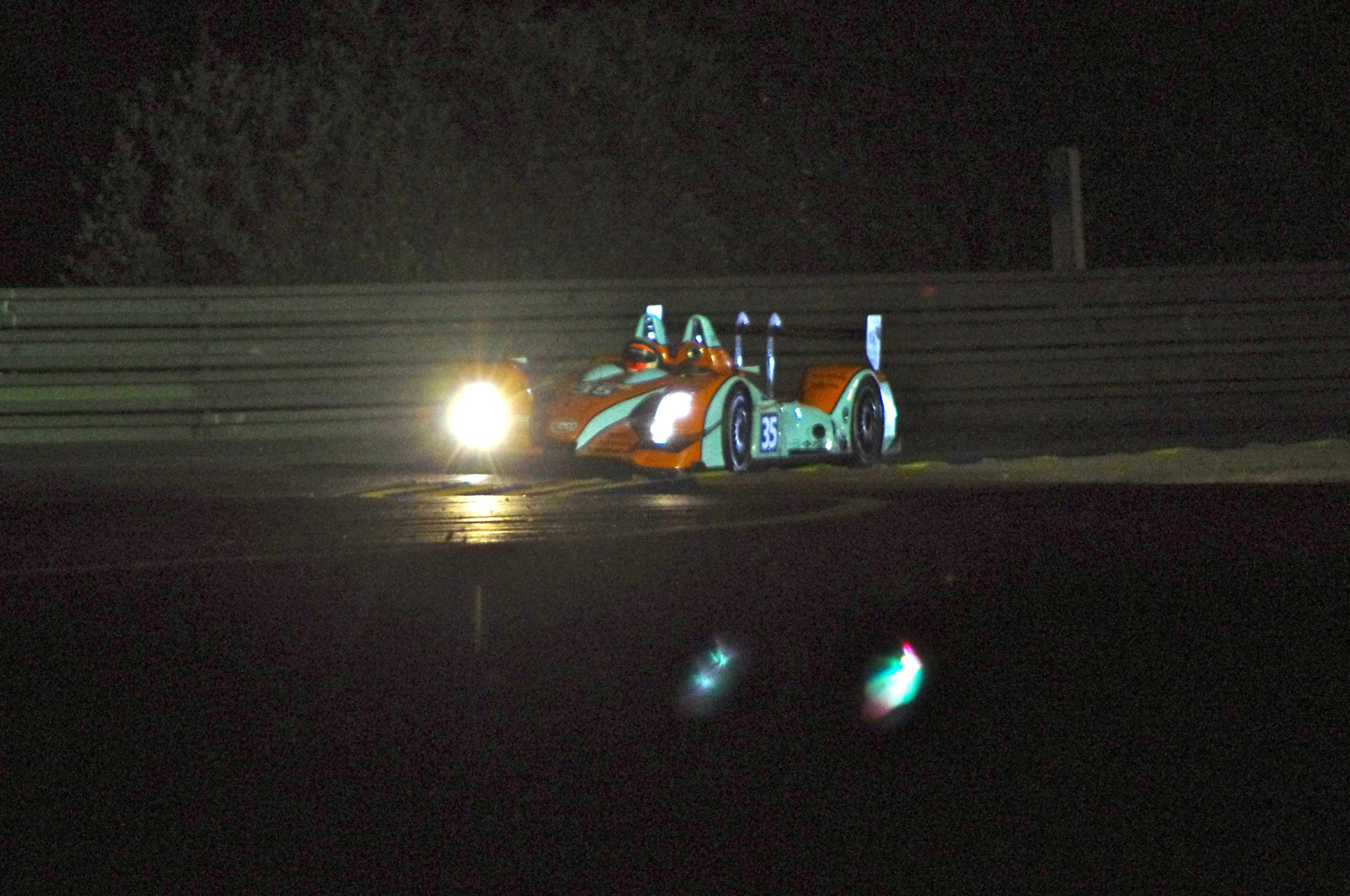 an orange car in the dark with lights on it