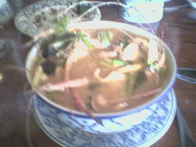 a blue and white plate full of soup on a table