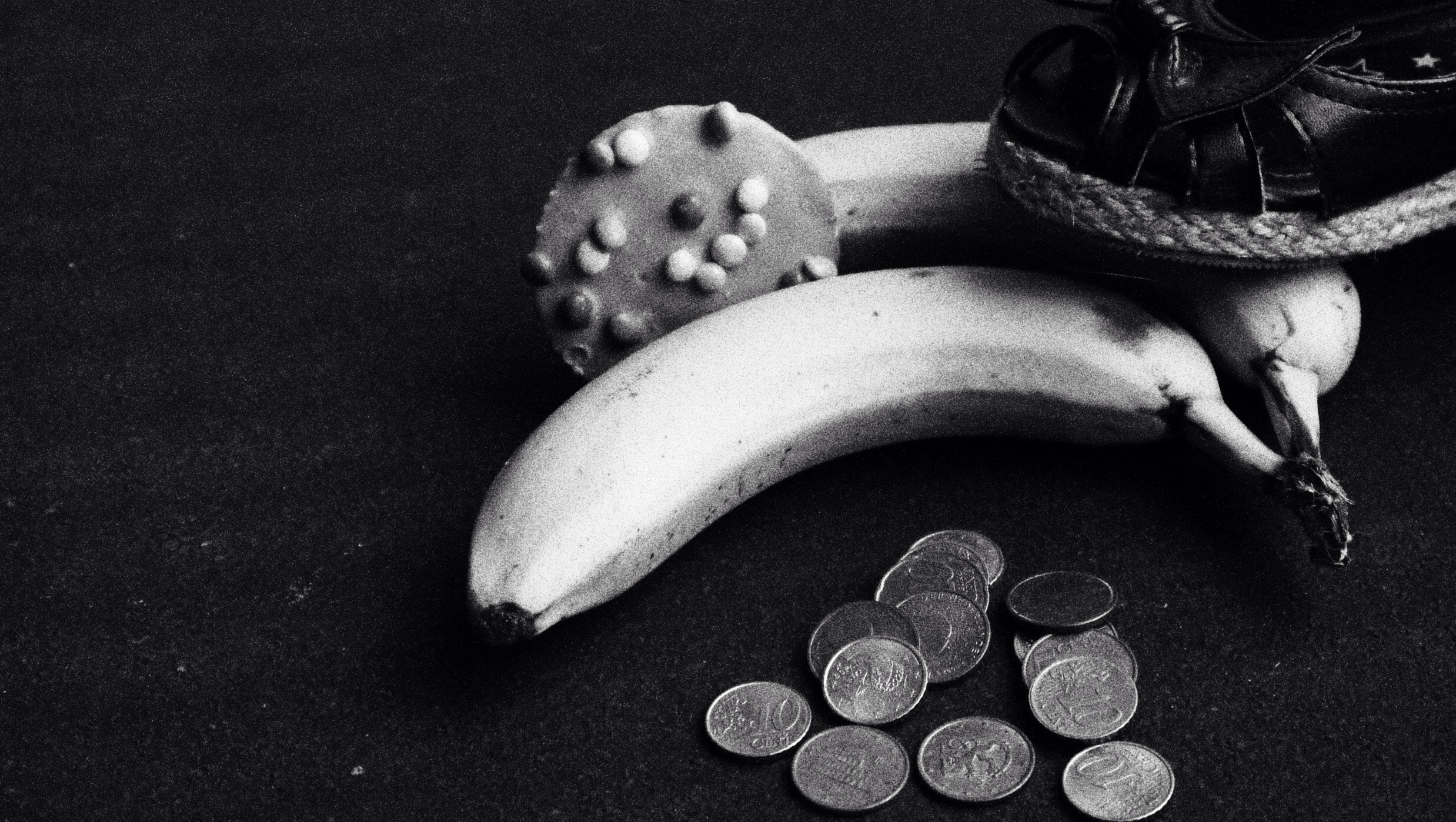 some different coins and some banana sitting on the table