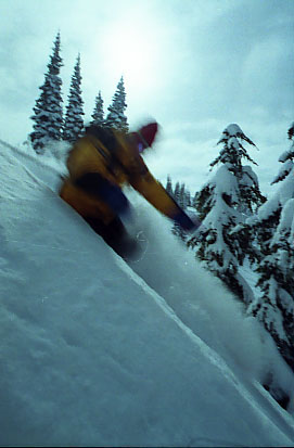 a snowboarder is going down a steep slope