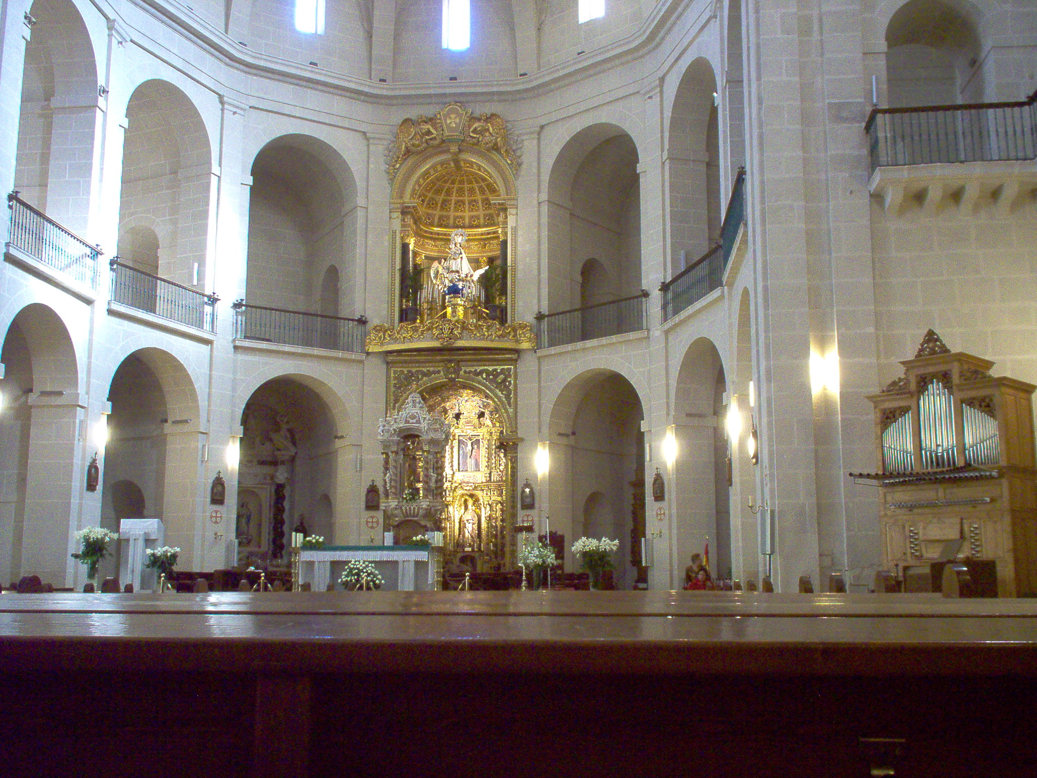 the inside of a church with arches and a statue of christ