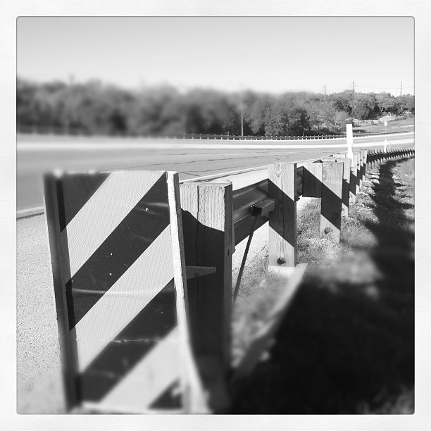 black and white pograph of several barriers near a highway