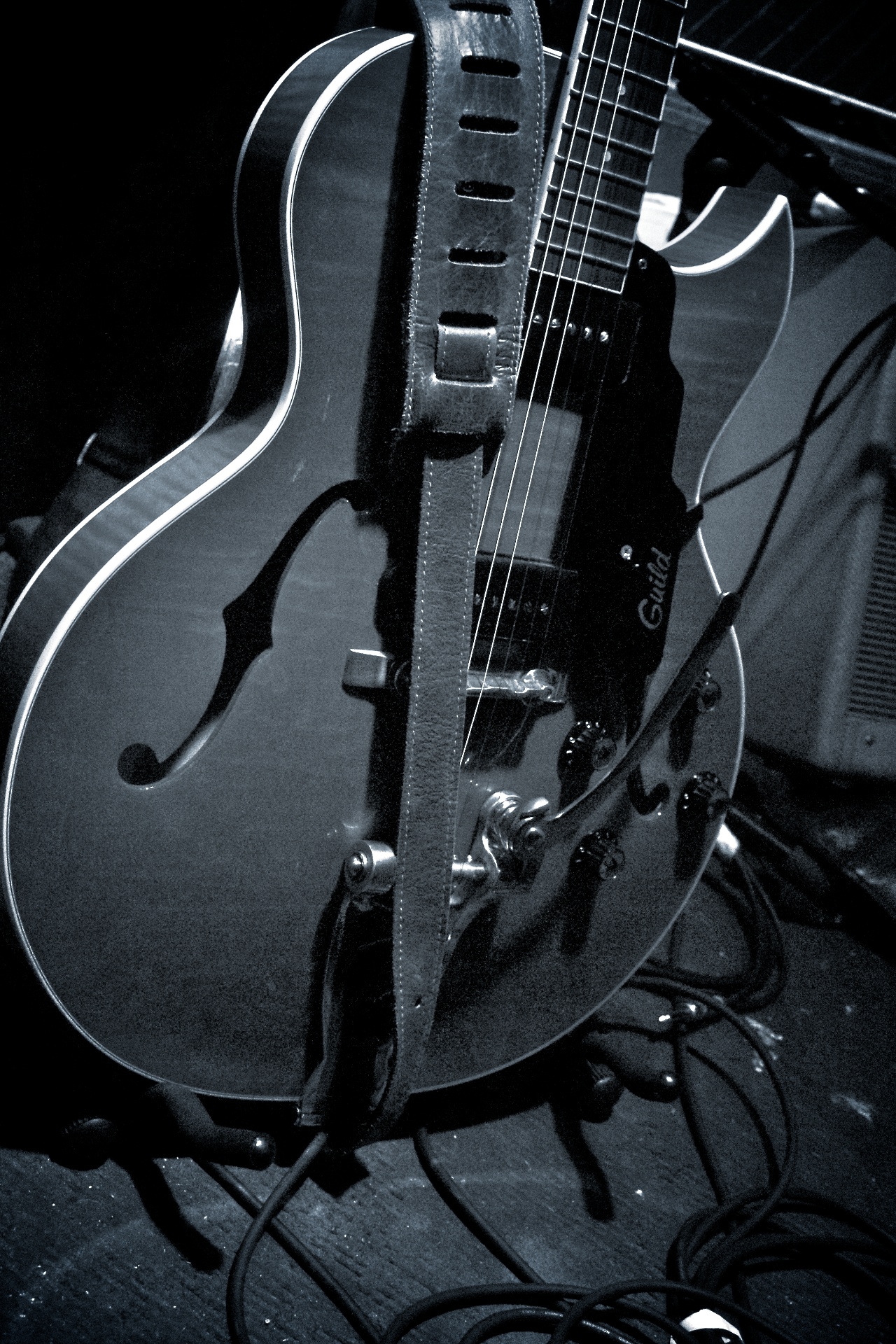 an electric guitar sitting on the ground in black and white