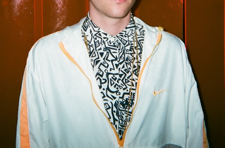 a man wearing a jacket and tie near an elevator