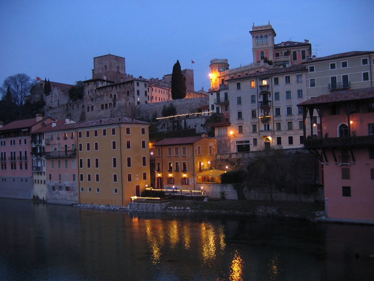 a city at dusk on the bank of a river