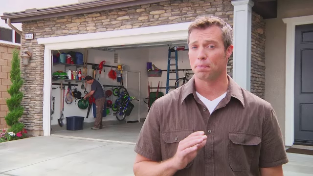 a man in brown shirt standing next to a garage