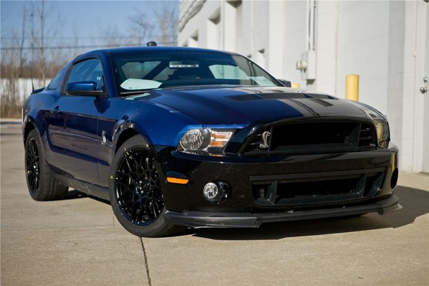 the blue mustang car is parked in front of a building