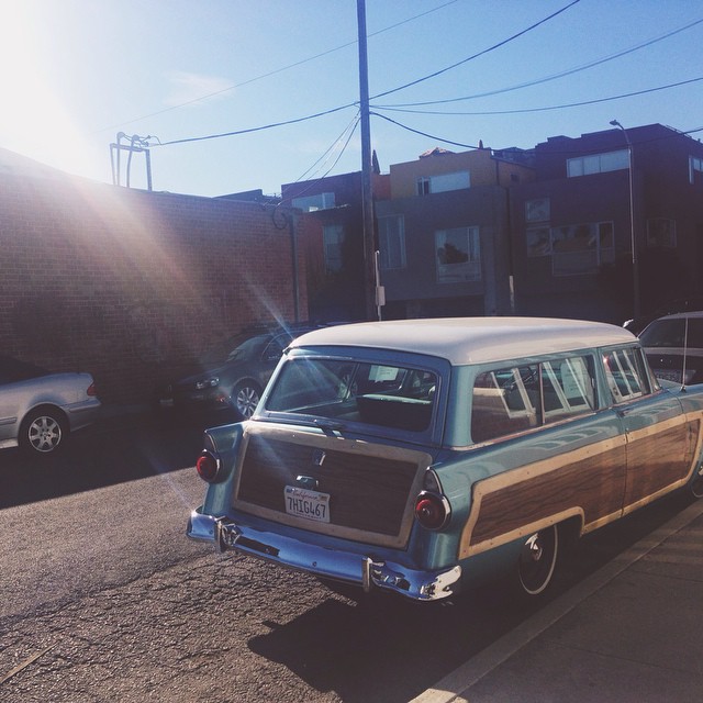 a station wagon station wagon parked in a street next to houses