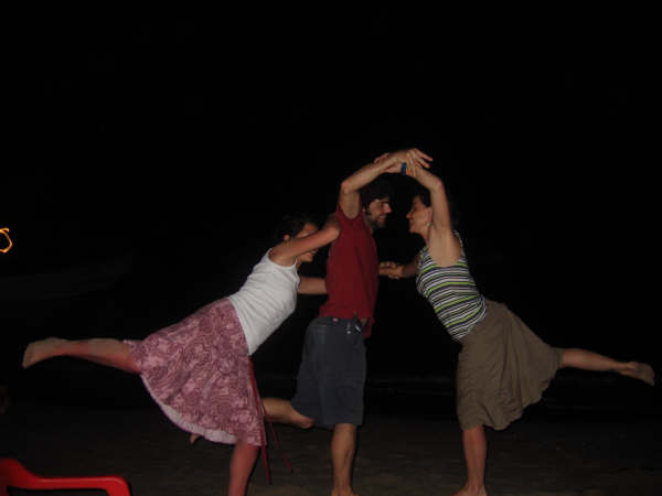 three people doing a handstand with a red plastic chair