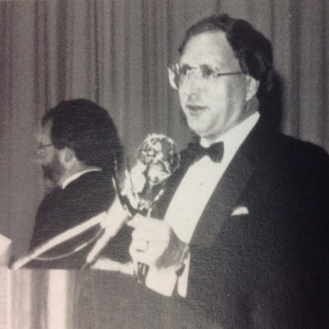 a man in a tuxedo holding a trophy