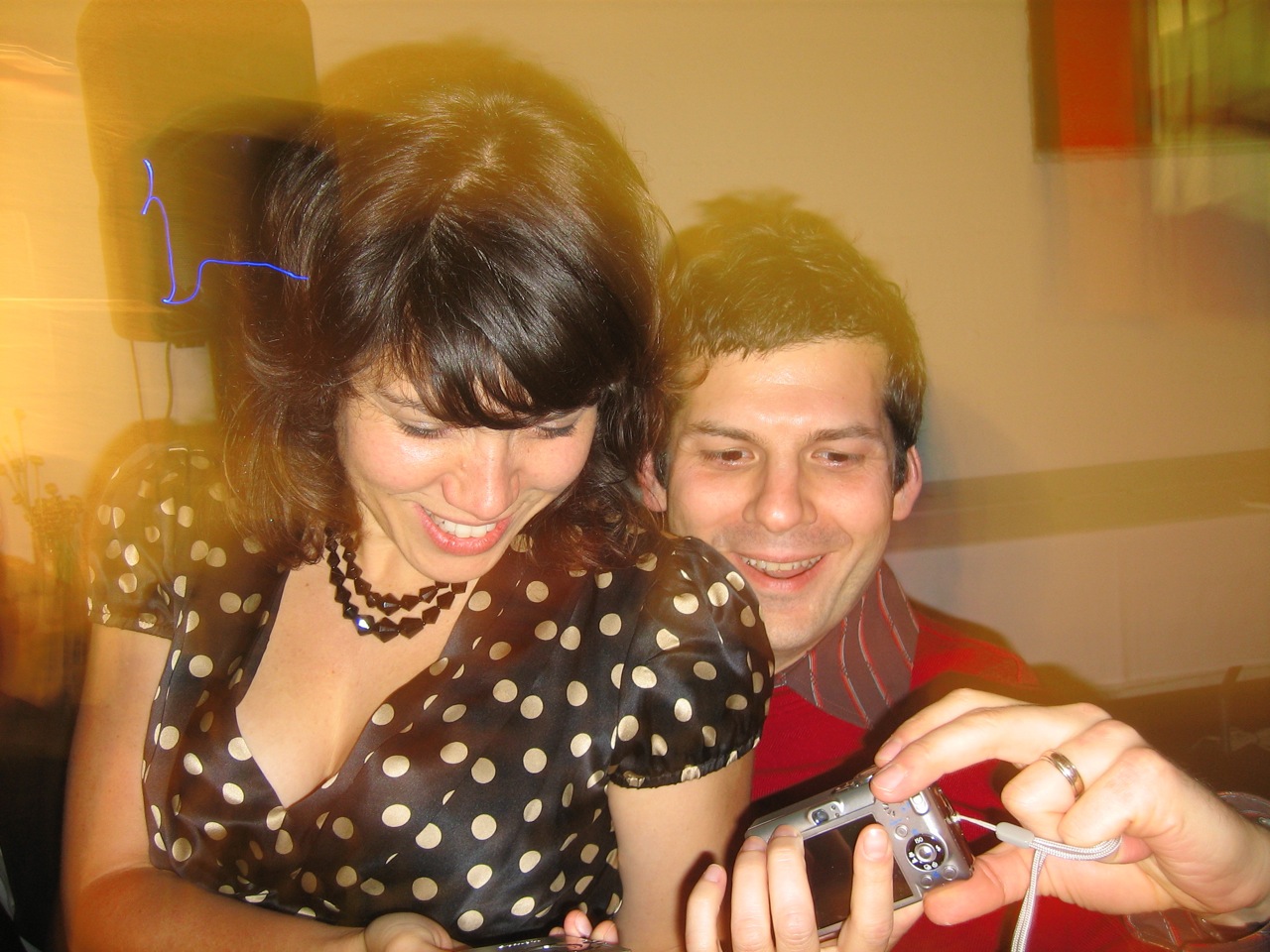 a young couple looking at a small camera