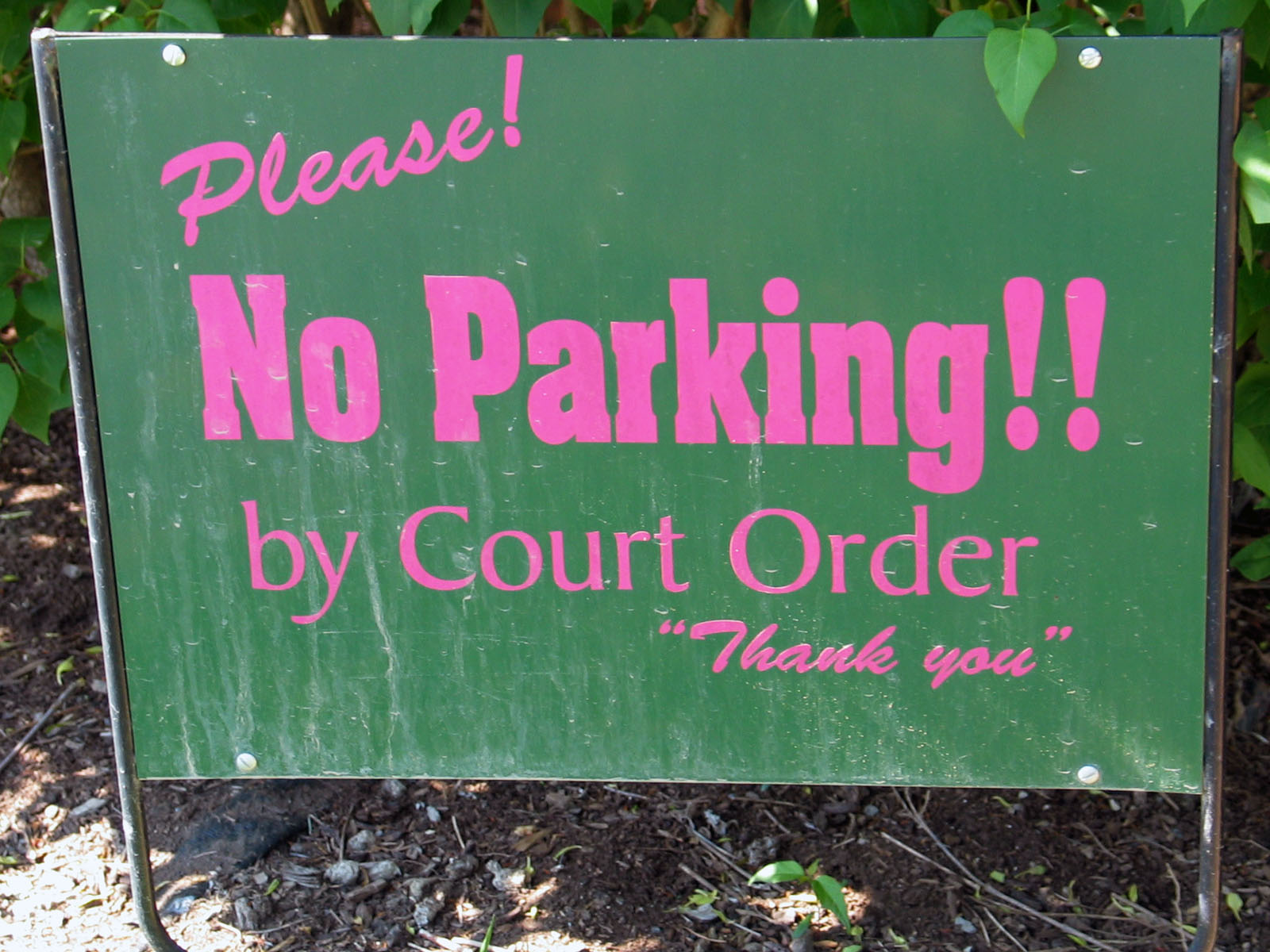 a green sign with pink writing on it