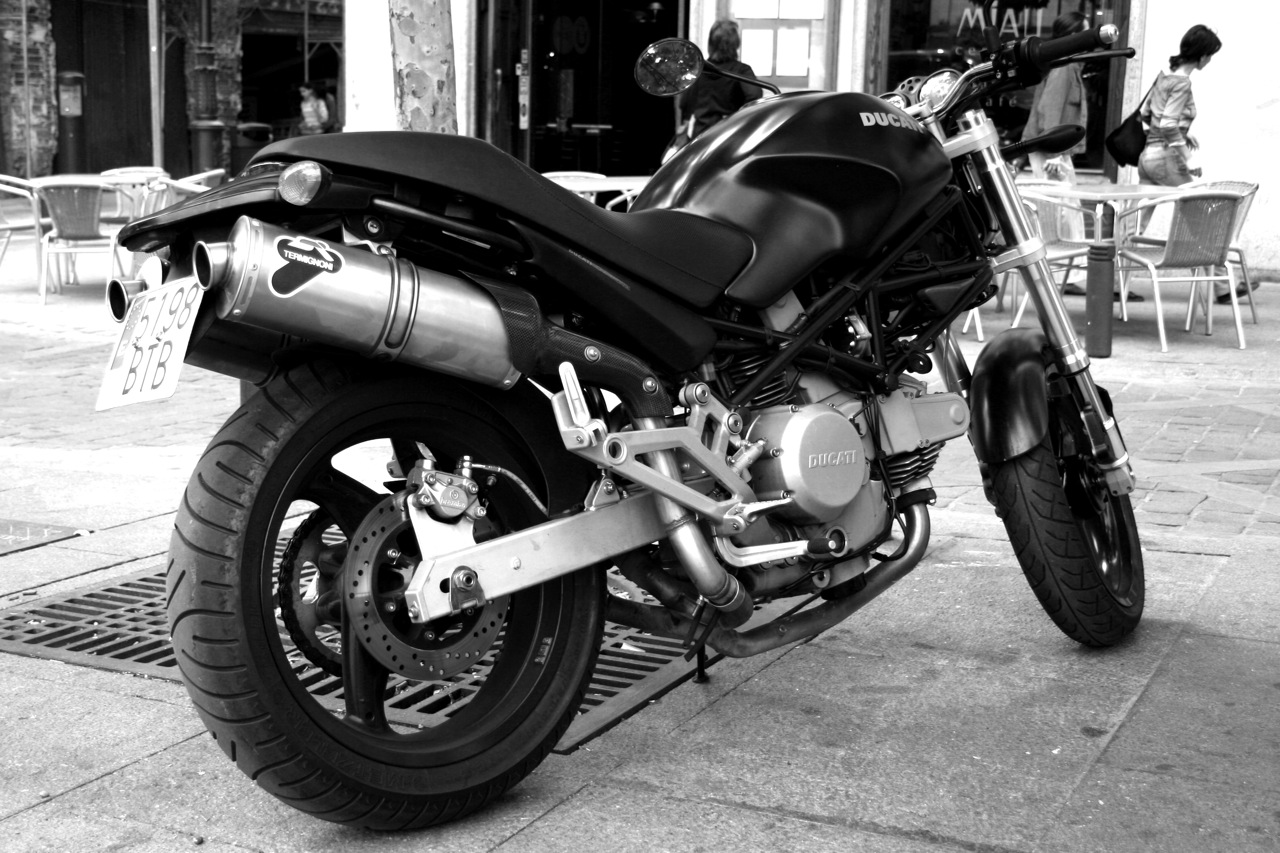 a motorcycle parked in front of a building on a sidewalk