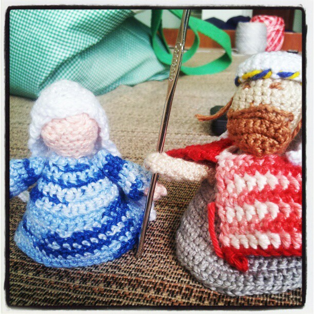 crochet knitted doll in colorful outfits holding the needle