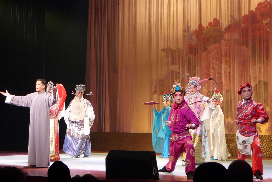 four men in oriental costumes standing on stage