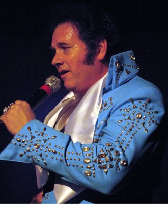 a person wearing a blue suit and white shirt holding a microphone