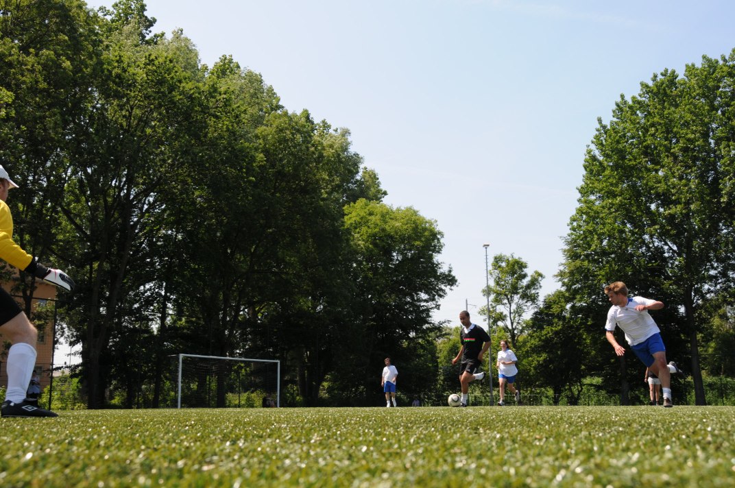 people playing a game of frisbee on an open grass field