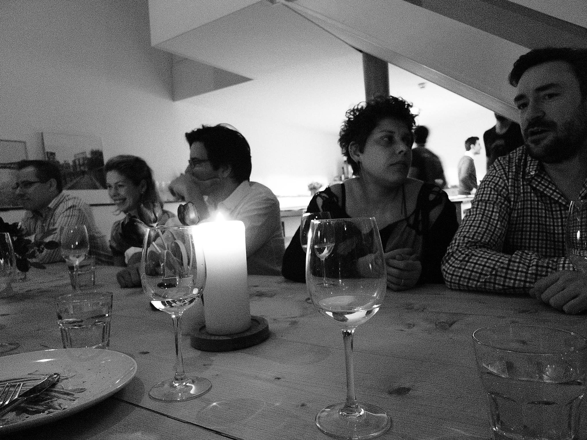 people sitting at a table near a small candle