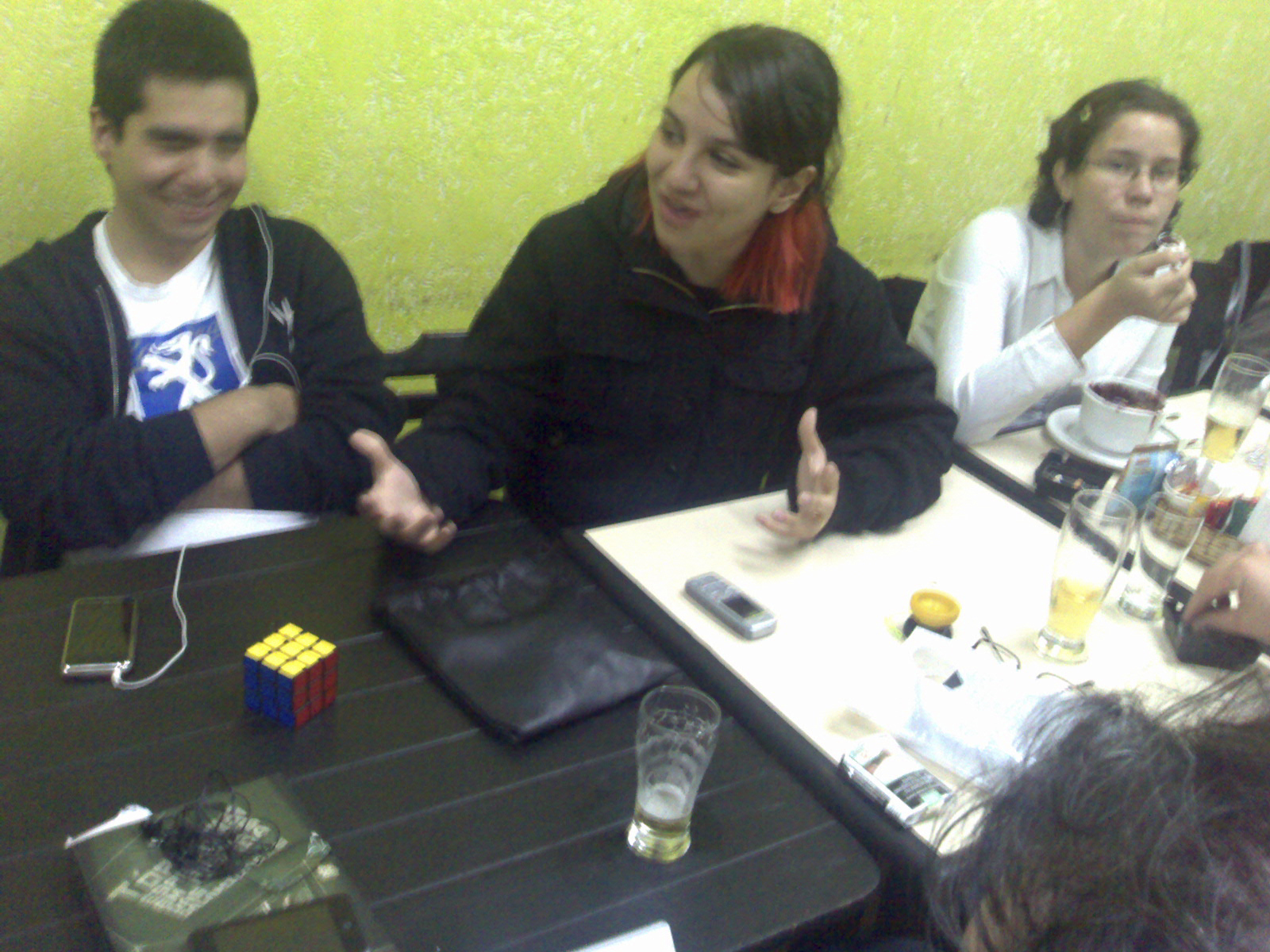 a group of people sitting at a table with a smart phone
