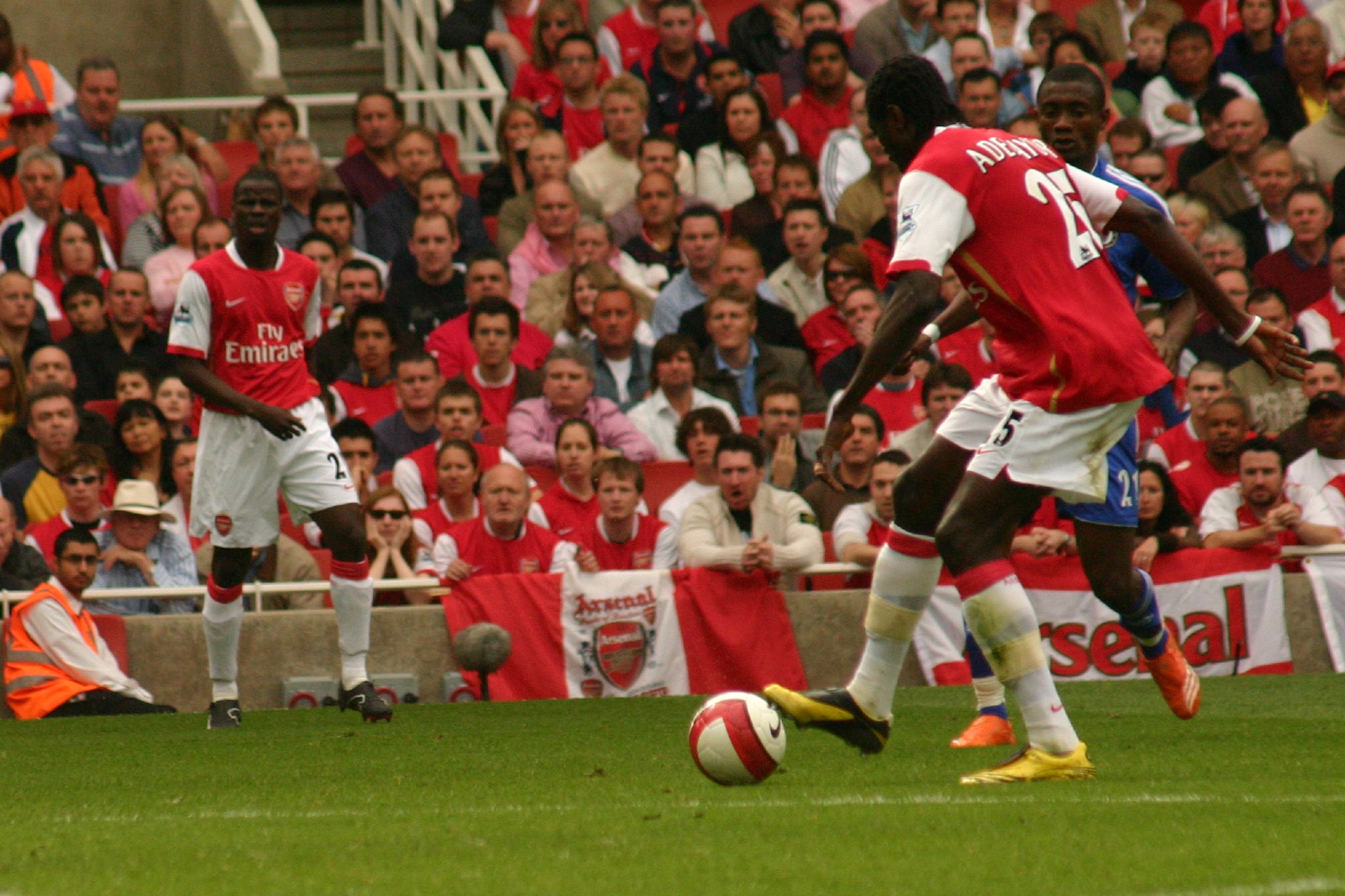 two soccer players fighting for the ball in front of spectators