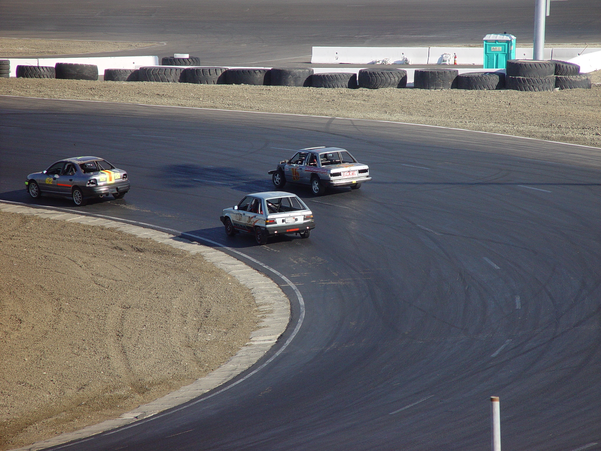 four police cars drive around the bend during a race