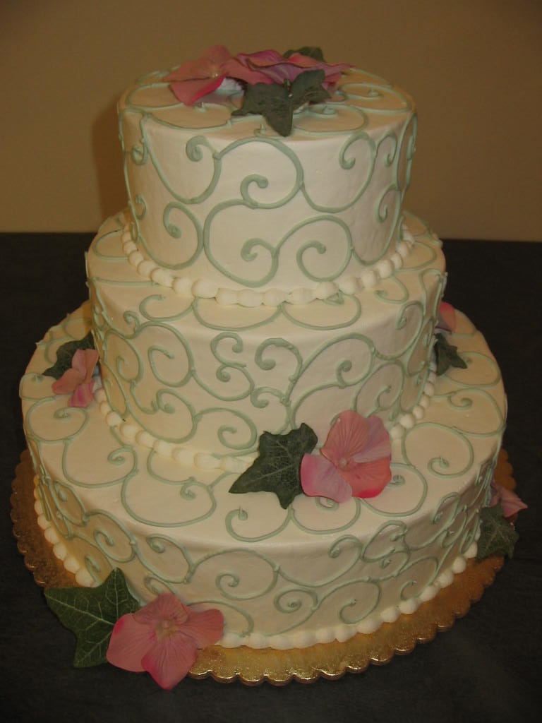 a wedding cake with white and pink flowers