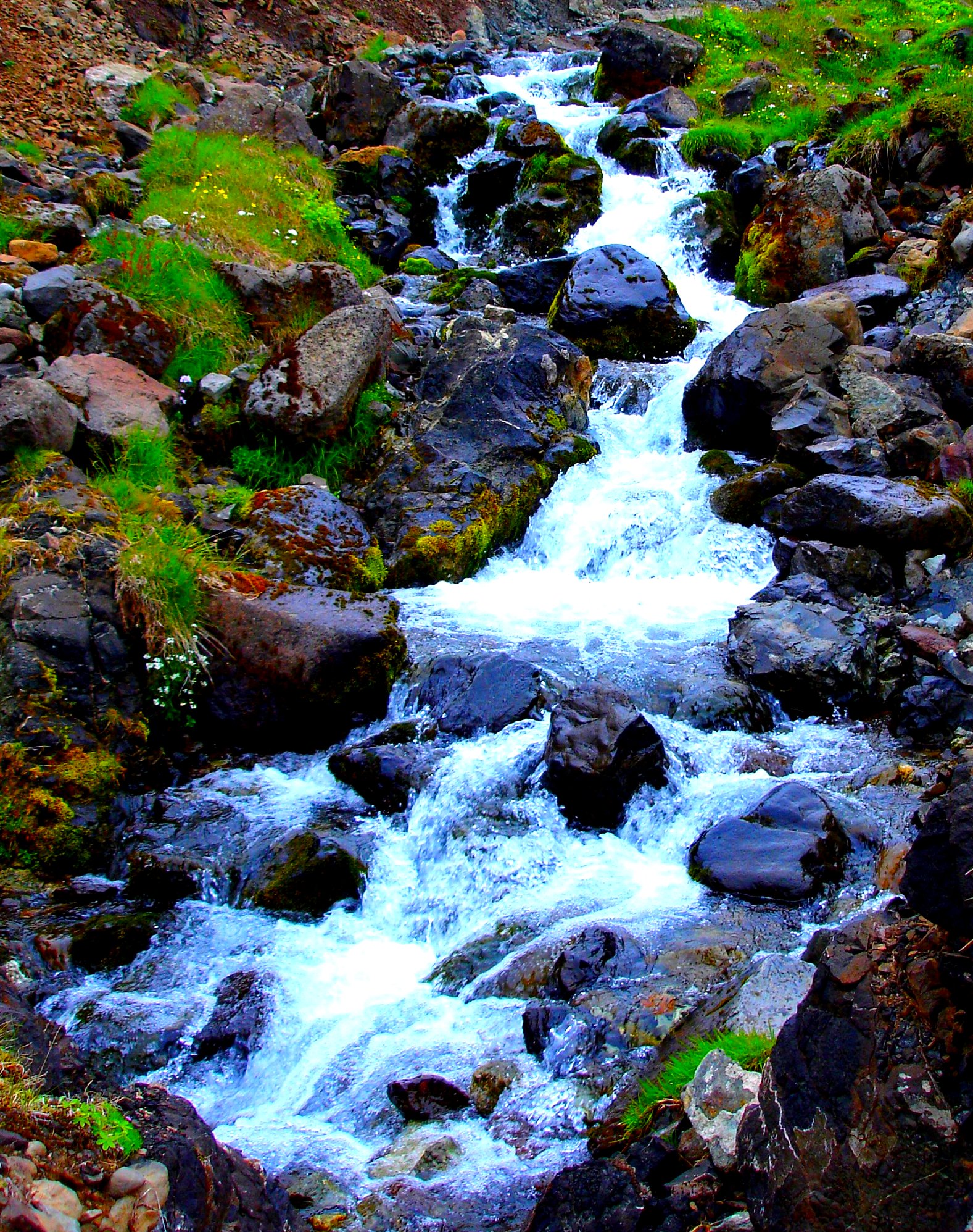 a small stream flowing between two large rocks