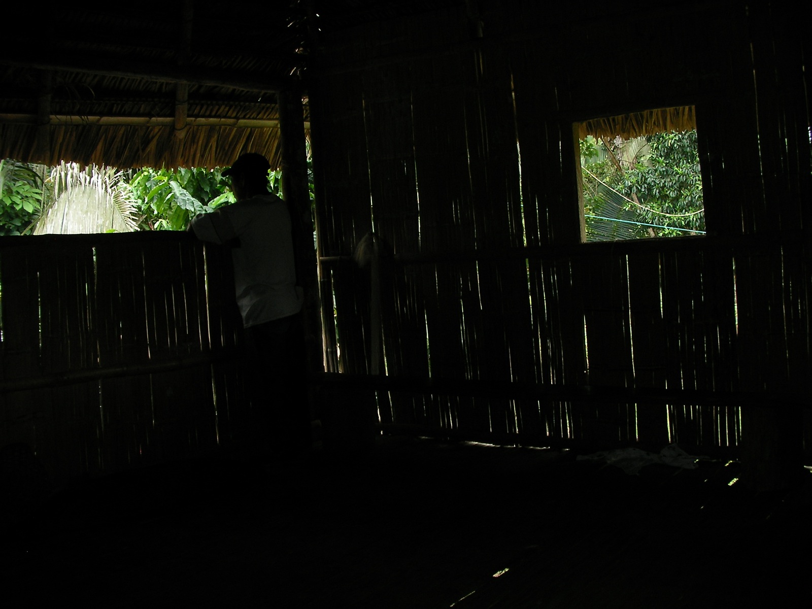 a man standing outside in a hut with curtains