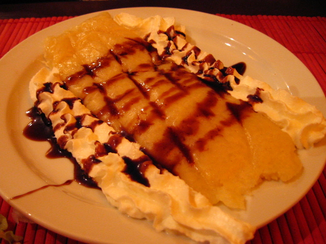 a banana split with chocolate syrup on top on a plate