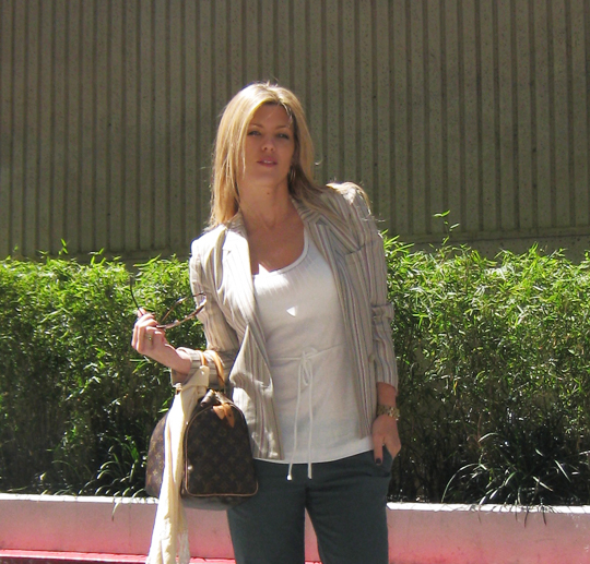 a beautiful young blond woman holding a hand bag